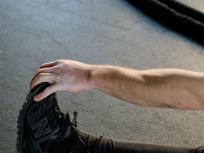 Person stretching their legs on a dark background